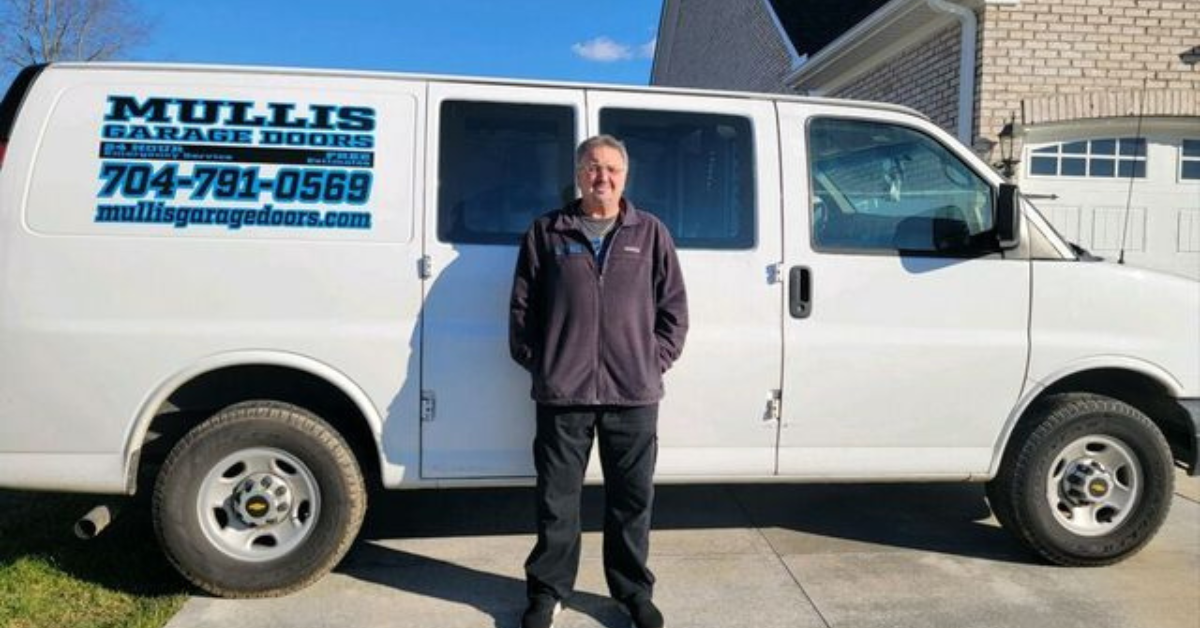 danny mullis owner operator standing by mullis garage door truck